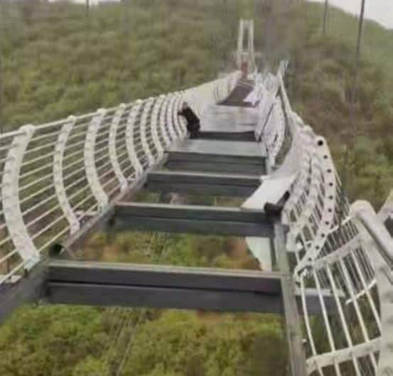 Tourist in China left hanging from 330 ft high glass bridge as wind blows away its panels 2